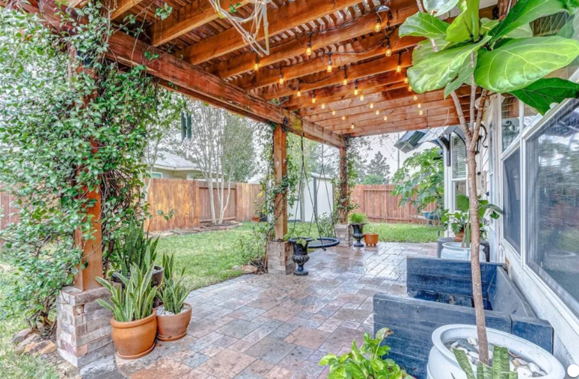 Wood pergola over a backyard patio with string lights